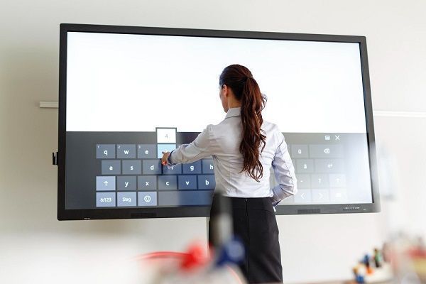 femme écrivant sur tableau interactif