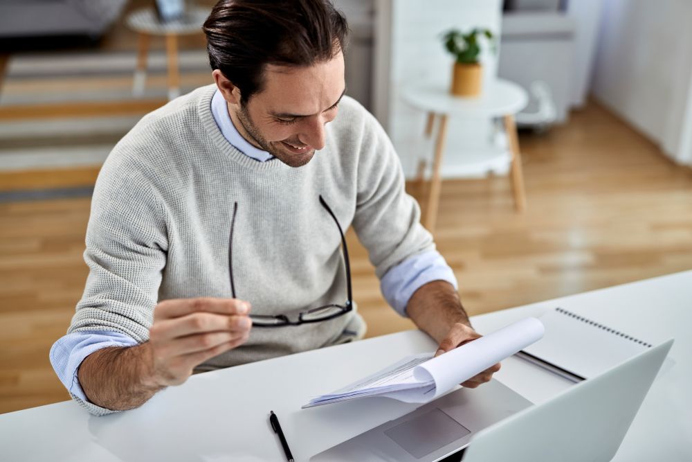 Un professionnel contrôlant des documents de facturation et des données comptables.
