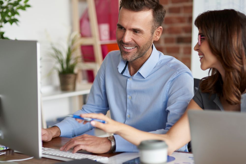 Deux collaborateurs devant un ordinateur testent l’automatisation du dépôt de factures sur Chorus Pro.