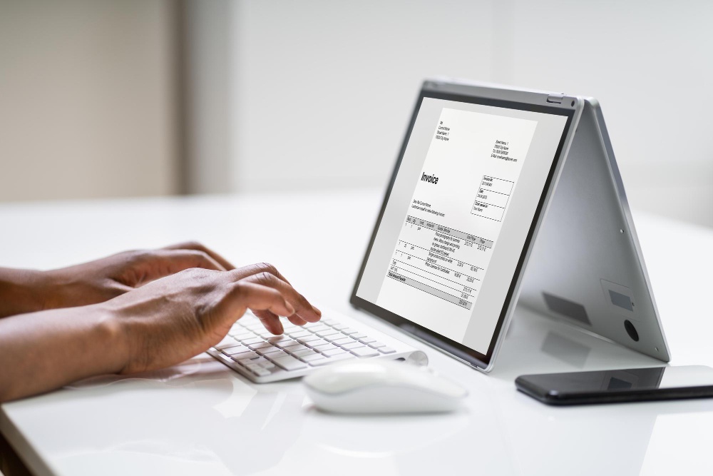 Personne consultant une facture numérique sur un ordinateur portable